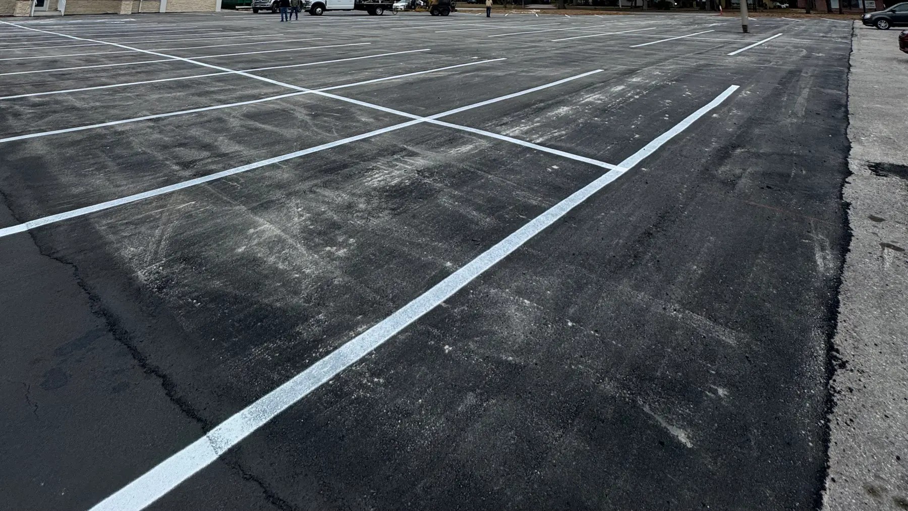 Parking lot striping in Hudson, FL: new white parking-space lines on commercial asphalt